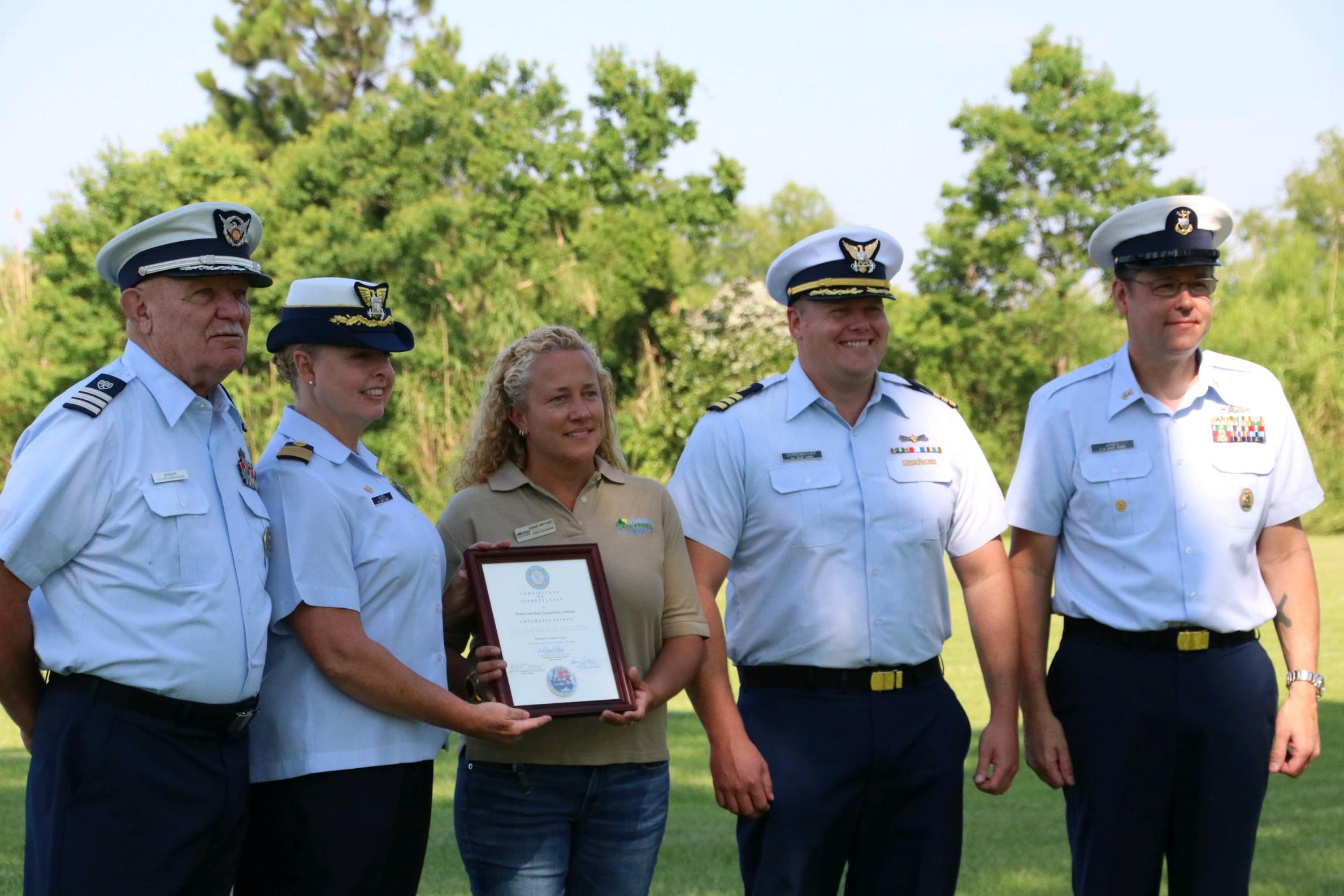 Sector Mobile Commanding Officer LaDonn Allen and other Coast Guard officers present Meaher State Park Superintendent Anna Bryant with a certificate of appreciation.